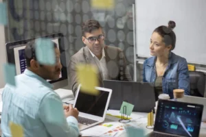 Equipa de PME em reunião com projeções digitais de inteligência artificial e gráficos de produtividade.